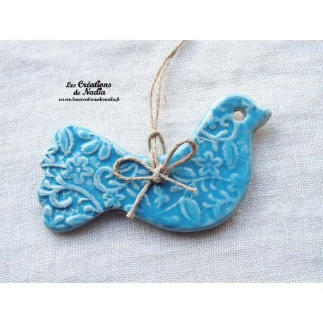 Oiseau en céramique, couleur bleu lagon impressions fines dentelles